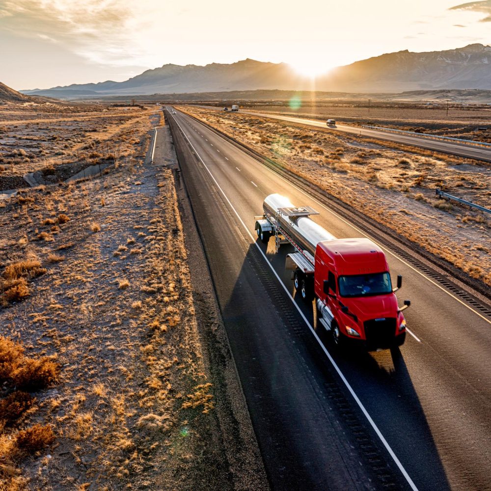 Red Cab Tanker Truck Speeding Down Interstate Seventy in Utah during a beautiful sunset heading eastbound in the desert